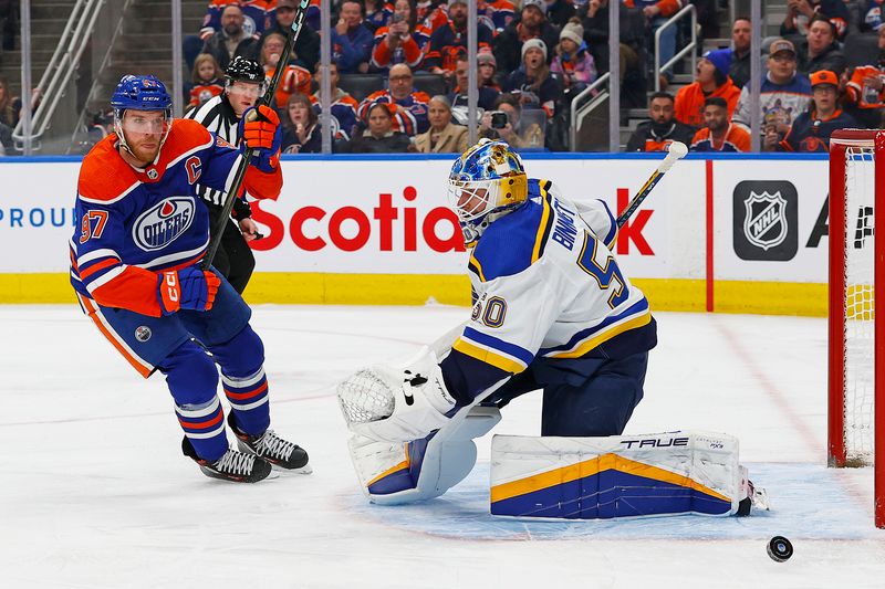 Feb 28, 2024; Edmonton, Alberta, CAN; Edmonton Oilers forward Connor McDavid (97) chases a loose puck beside St. Louis Blues goaltender Jordan Binnington (50) during the first period at Rogers Place. Mandatory Credit: Perry Nelson-USA TODAY Sports