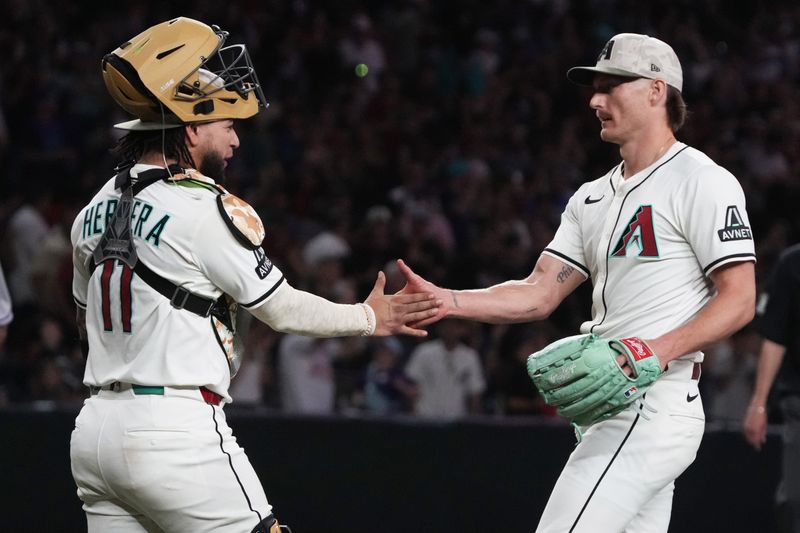 May 18, 2025; Phoenix, Arizona, USA; Arizona Diamondbacks catcher Jose Herrera (11) and pitcher Shelby Miller (18) celebrate after defeating the Colorado Rockies at Chase Field. Mandatory Credit: Rick Scuteri-Imagn Images