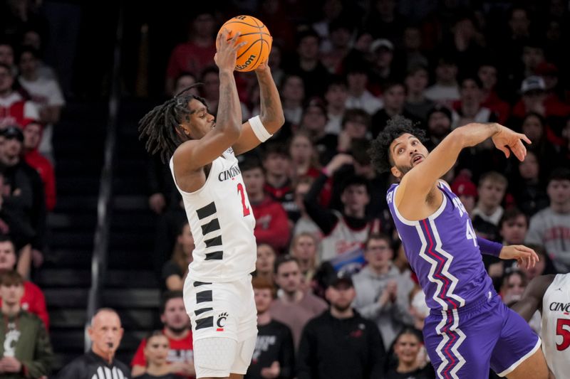 Jan 16, 2024; Cincinnati, Ohio, USA;  Cincinnati Bearcats guard Jizzle James (2) grabs a rebound against TCU Horned Frogs forward Essam Mostafa (44) in the first half at Fifth Third Arena. Mandatory Credit: Aaron Doster-USA TODAY Sports