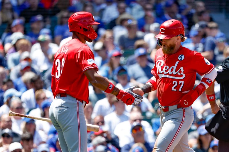 Jun 2, 2024; Chicago, Illinois, USA; Cincinnati Reds outfielder Jake Fraley (27) is congratulated by outfielder Will Benson (30) after scoring against the Chicago Cubs during the second inning at Wrigley Field. Mandatory Credit: Kamil Krzaczynski-USA TODAY Sports