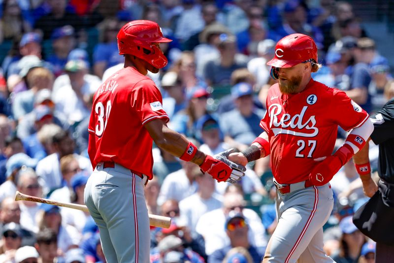 Jun 2, 2024; Chicago, Illinois, USA; Cincinnati Reds outfielder Jake Fraley (27) is congratulated by outfielder Will Benson (30) after scoring against the Chicago Cubs during the second inning at Wrigley Field. Mandatory Credit: Kamil Krzaczynski-USA TODAY Sports