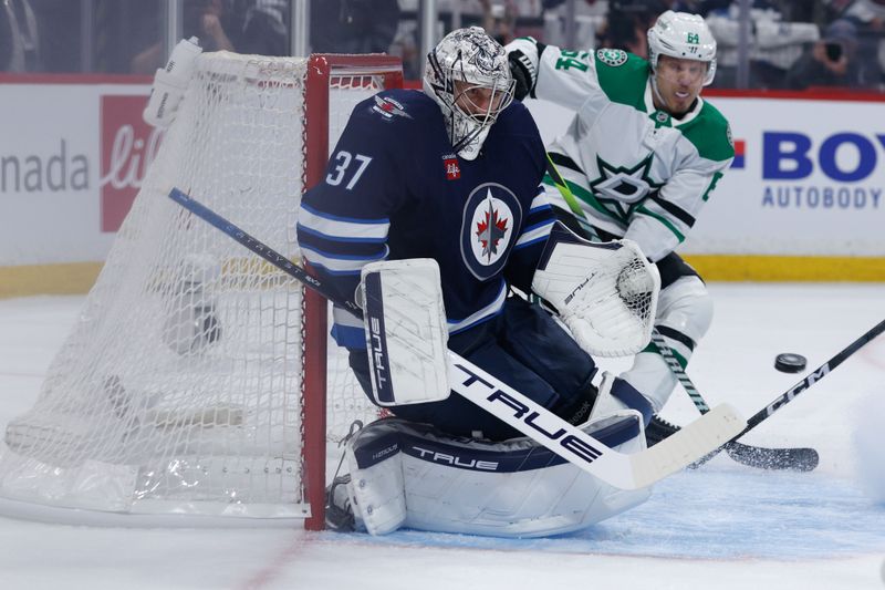 May 15, 2025; Winnipeg, Manitoba, CAN; Winnipeg Jets goalie Connor Hellebuyck (37) watches a Dallas Stars shot during the first period in game five of the second round of the 2025 Stanley Cup Playoffs at Canada Life Centre. Mandatory Credit: Terrence Lee-Imagn Images