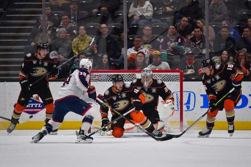 Feb 21, 2024; Anaheim, California, USA; Anaheim Ducks defenseman Pavel Mintyukov (34) defenseman Ilya Lyubushkin (46) and center Ryan Strome (16) help goaltender John Gibson (36) defend the goal against Columbus Blue Jackets center Boone Jenner (38) during the first period at Honda Center. Mandatory Credit: Gary A. Vasquez-USA TODAY Sports