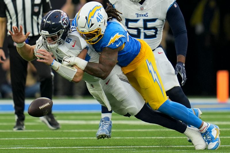 Tennessee Titans quarterback Will Levis (8) fumbles the ball as he is sacked by Los Angeles Chargers linebacker Bud Dupree (48) during the second half of an NFL football game Sunday, Nov. 10, 2024, in Inglewood, Calif. (AP Photo/Gregory Bull)