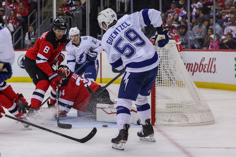 Oct 22, 2024; Newark, New Jersey, USA; New Jersey Devils goaltender Jake Allen (34) makes a save on Tampa Bay Lightning center Jake Guentzel (59) during the first period at Prudential Center. Mandatory Credit: Ed Mulholland-Imagn Images