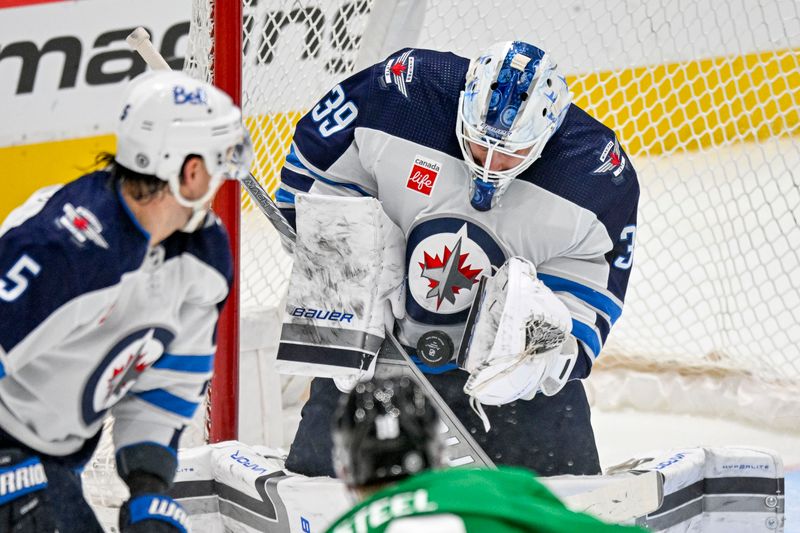 Apr 11, 2024; Dallas, Texas, USA; Winnipeg Jets goaltender Laurent Brossoit (39) stops a shot by Dallas Stars center Sam Steel (18) during the first period at the American Airlines Center. Mandatory Credit: Jerome Miron-USA TODAY Sports