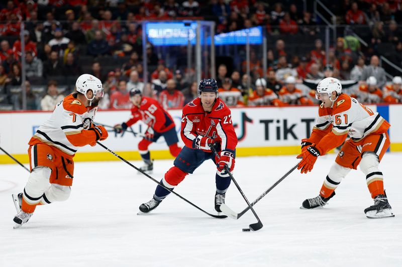 Jan 14, 2025; Washington, District of Columbia, USA; Washington Capitals right wing Brandon Duhaime (22) battles for the puck with Anaheim Ducks defenseman Radko Gudas (7) and Ducks left wing Cutter Gauthier (61) in the first period at Capital One Arena. Mandatory Credit: Geoff Burke-Imagn Images