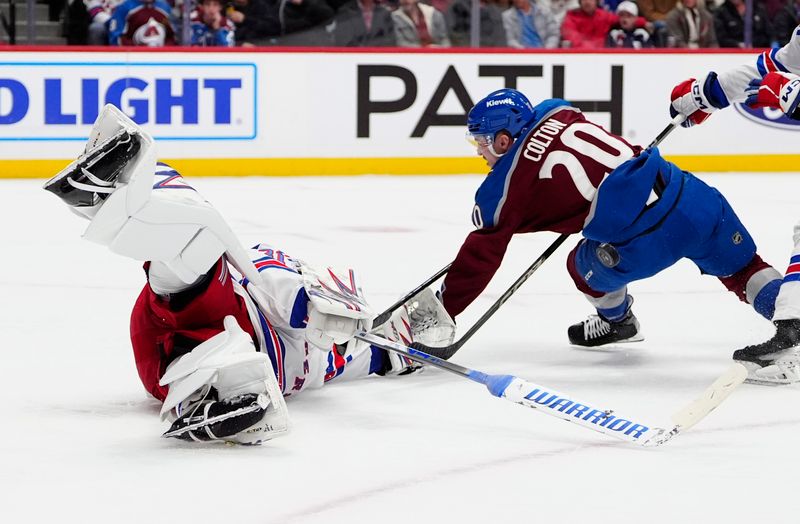 Jan 14, 2025; Denver, Colorado, USA; Colorado Avalanche center Ross Colton (20) collides into New York Rangers goaltender Igor Shesterkin (31) in the second period at Ball Arena. Mandatory Credit: Ron Chenoy-Imagn Images