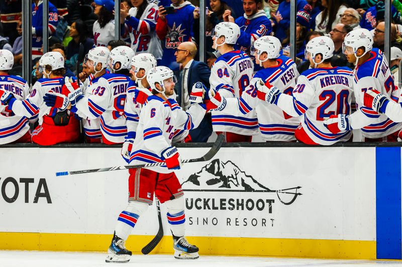 Nov 17, 2024; Seattle, Washington, USA; New York Rangers defenseman Zac Jones (6) high fives teammates on the bench after scoring a goal against the Seattle Kraken during the third period at Climate Pledge Arena. Mandatory Credit: Joe Nicholson-Imagn Images