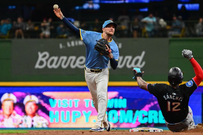 Jul 26, 2024; Milwaukee, Wisconsin, USA; Milwaukee Brewers second baseman Brice Turang (2) completes a double play after forcing out Miami Marlins right fielder Jesus Sanchez (12) in the fifth inning at American Family Field. Mandatory Credit: Benny Sieu-USA TODAY Sports