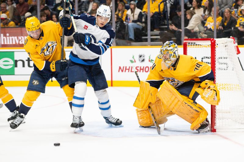 Nov 23, 2024; Nashville, Tennessee, USA;  Nashville Predators goaltender Juuse Saros (74) blocks the deflection Winnipeg Jets center Rasmus Kupari (15) during the second period at Bridgestone Arena. Mandatory Credit: Steve Roberts-Imagn Images