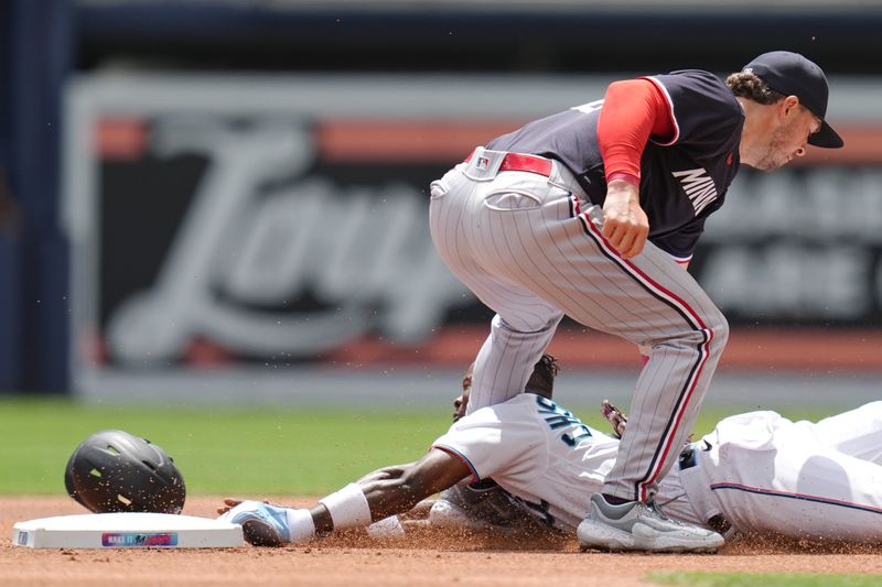 Apr 5, 2023; Miami, Florida, USA;  Miami Marlins center fielder Jazz Chisholm Jr. (2) gets tagged out by Minnesota Twins second baseman Kyle Farmer (12) in the first inning at loanDepot Park. Mandatory Credit: Jim Rassol-USA TODAY Sports