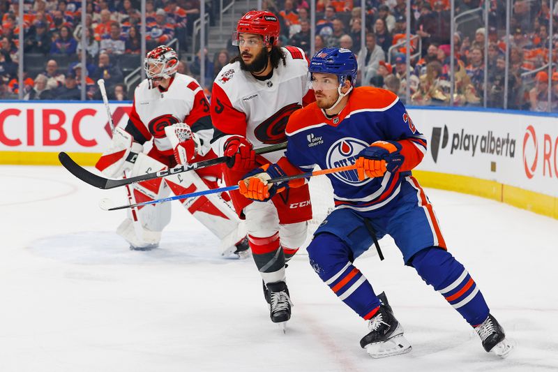 Mar 6, 2026; Edmonton, Alberta, CAN; Edmonton Oilers forward Jack Roslovic (28) and Carolina Hurricanes defensemen Jalen Chatfield (5) battles for position during the first period at Rogers Place. Mandatory Credit: Perry Nelson-Imagn Images