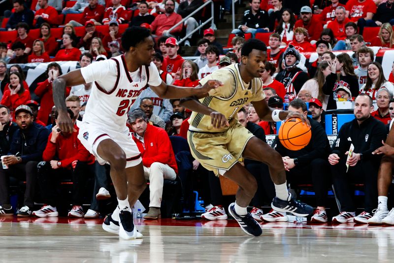 Jan 17, 2026; Raleigh, North Carolina, USA; Georgia Tech Yellow Jackets guard Lamar Washington (1) dribbles with the ball guarded by NC State Wolfpack guard Terrance Arceneaux (21) during the first half of the game at Lenovo Center. Mandatory Credit: Jaylynn Nash-Imagn Images
