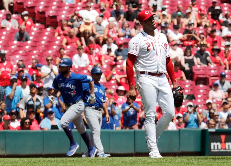 Aug 20, 2023; Cincinnati, Ohio, USA; Cincinnati Reds starting pitcher Hunter Greene (21) walks back to the mound after giving up a two-run home run to Toronto Blue Jays designated hitter Brandon Belt (left) during the second inning at Great American Ball Park. Mandatory Credit: David Kohl-USA TODAY Sports