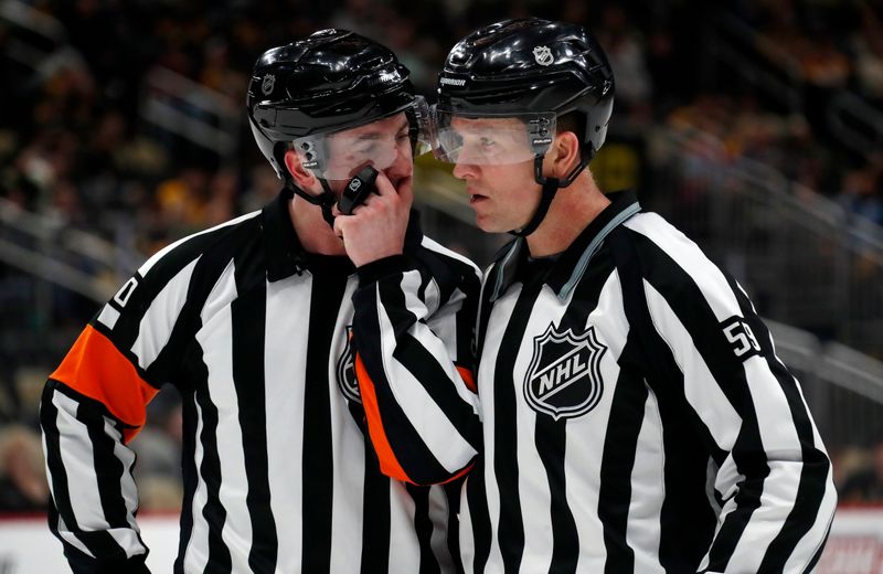 Mar 5, 2024; Pittsburgh, Pennsylvania, USA; NHL referee Mitch Dunning (left) and linesman Steve Barton (59) talk during the third period of the game between the Columbus Blue Jackets and the Pittsburgh Penguins at PPG Paints Arena. The Penguins won 5-3. Mandatory Credit: Charles LeClaire-USA TODAY Sports