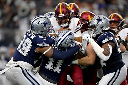 Washington Commanders quarterback Jayden Daniels (5) is sacked by Dallas Cowboys defensive end Chauncey Golston (99) and linebacker Micah Parsons (11) and defensive tackle Osa Odighizuwa (97) during an NFL football game in Arlington, Texas, Sunday, Jan. 5, 2025. (AP Photo/Jerome Miron)