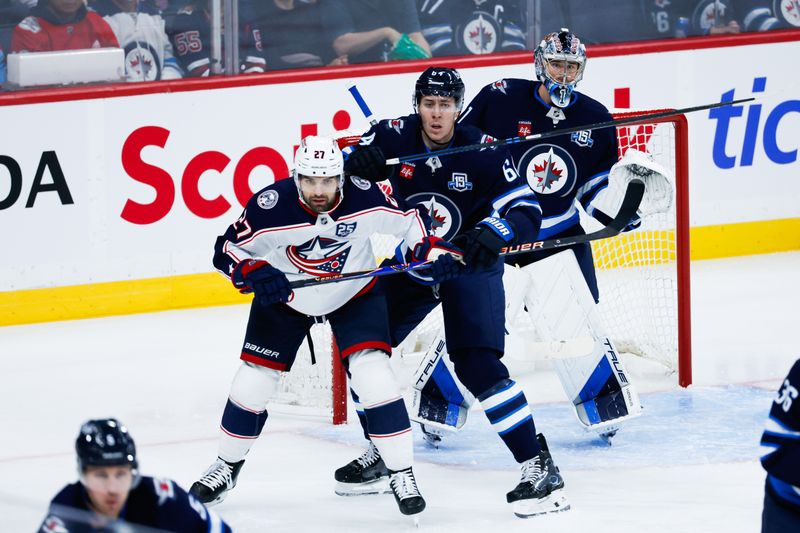 Nov 18, 2025; Winnipeg, Manitoba, CAN;  Columbus Blue Jackets forward Zachary Aston-Reese (27) jostles for position with Winnipeg Jets defenseman Logan Stanley (64) during the second period at Canada Life Centre. Mandatory Credit: Terrence Lee-Imagn Images