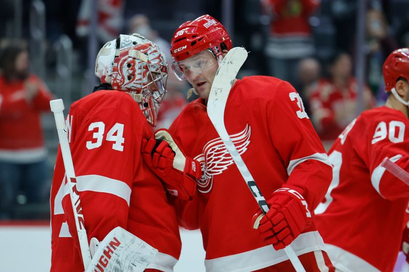 Nov 30, 2023; Detroit, Michigan, USA; Detroit Red Wings goaltender Alex Lyon (34) receives congratulations from right wing Christian Fischer (36) after the game against the Chicago Blackhawks at Little Caesars Arena. Mandatory Credit: Rick Osentoski-USA TODAY Sports