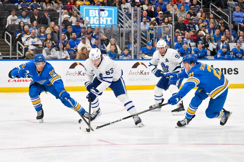 Mar 28, 2026; St. Louis, Missouri, USA; St. Louis Blues defenseman Logan Mailloux (23) and right wing Jimmy Snuggerud (21) defend against Toronto Maple Leafs right wing Easton Cowan (53) during the first period at Enterprise Center. Mandatory Credit: Jeff Curry-Imagn Images