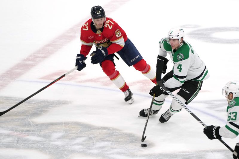 Dec 6, 2023; Sunrise, Florida, USA; Dallas Stars defenseman Miro Heiskanen (4) brings the puck up the ice as Florida Panthers center Eetu Luostarinen (27) closes in during the second period at Amerant Bank Arena. Mandatory Credit: Jim Rassol-USA TODAY Sports