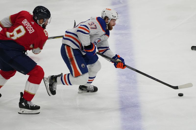Jun 24, 2024; Sunrise, Florida, USA; Edmonton Oilers forward Warren Foegele (37) controls the puck  against Florida Panthers forward Kyle Okposo (8) during the first period in game seven of the 2024 Stanley Cup Final at Amerant Bank Arena. Mandatory Credit: Jim Rassol-USA TODAY Sports