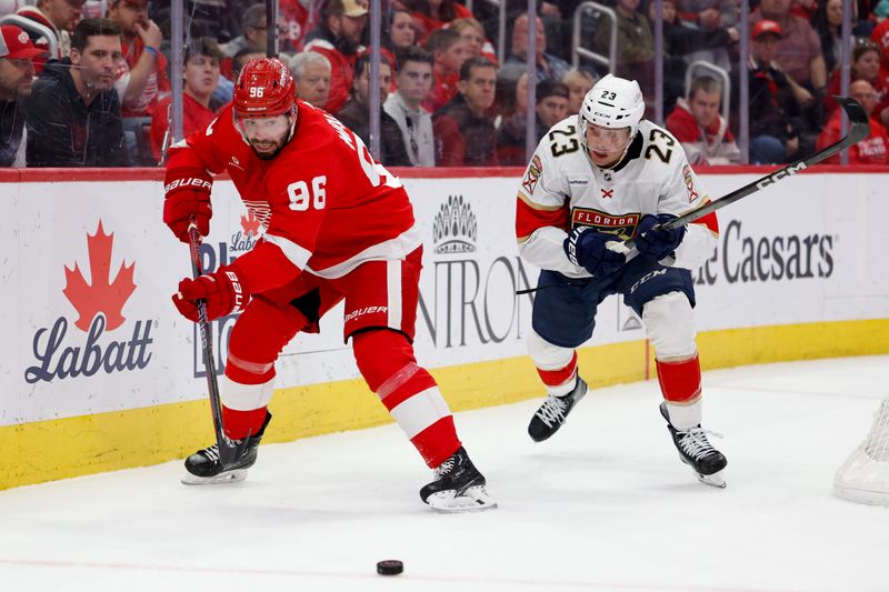 Mar 2, 2024; Detroit, Michigan, USA; Detroit Red Wings defenseman Jake Walman (96) skates with the puck chased by Florida Panthers center Carter Verhaeghe (23) in the first period at Little Caesars Arena. Mandatory Credit: Rick Osentoski-USA TODAY Sports