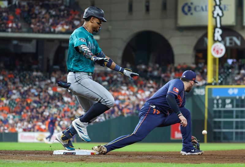 Sep 23, 2024; Houston, Texas, USA; Seattle Mariners center fielder Julio Rodriguez (44) is safe with an infield single as Houston Astros first baseman Victor Caratini (17) waits for the throw during the sixth inning at Minute Maid Park. Mandatory Credit: Troy Taormina-Imagn Images