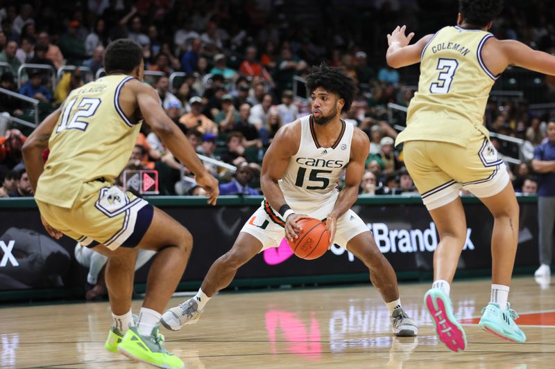 Feb 24, 2024; Coral Gables, Florida, USA; Miami Hurricanes forward Norchad Omier (15) controls the basketball as Georgia Tech Yellow Jackets forward Tyzhaun Claude (12) and guard Dallan Coleman (3) defend during the second half at Watsco Center. Mandatory Credit: Sam Navarro-USA TODAY Sports