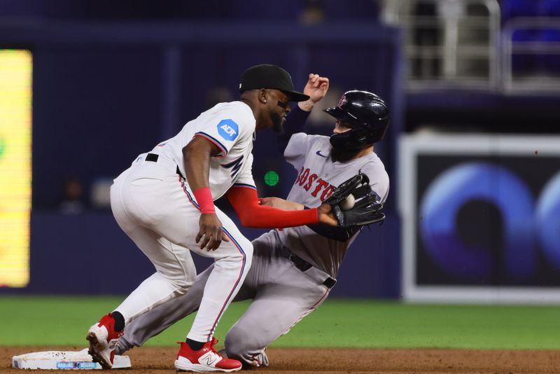 Jul 3, 2024; Miami, Florida, USA; Boston Red Sox catcher Connor Wong (12) steals second base against Miami Marlins shortstop Vidal Brujan (17) during the second inning at loanDepot Park. Mandatory Credit: Sam Navarro-USA TODAY Sports