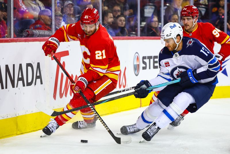 Oct 4, 2024; Calgary, Alberta, CAN; Calgary Flames center Kevin Rooney (21) and Winnipeg Jets center Gabriel Vilardi (13) battles for the puck during the first period at Scotiabank Saddledome. Mandatory Credit: Sergei Belski-Imagn Images