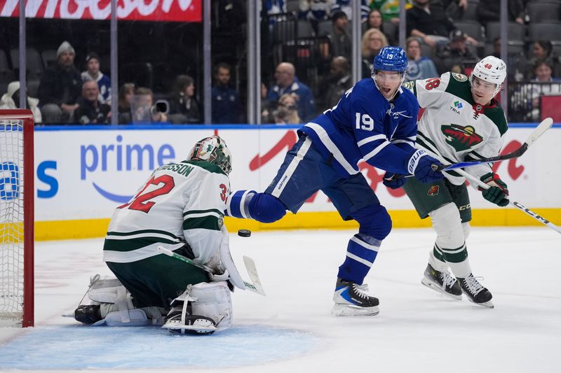 Jan 19, 2026; Toronto, Ontario, CAN; Toronto Maple Leafs forward Calle Jarnkrok (19) tries to deflect a shot against Minnesota Wild goaltender Filip Gustavsson (32) and defenseman Daemon Hunt (48) during the third period at Scotiabank Arena. Mandatory Credit: John E. Sokolowski-Imagn Images