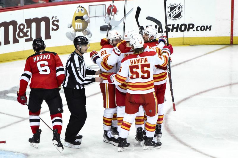 Feb 8, 2024; Newark, New Jersey, USA; Calgary Flames center Kevin Rooney (21) celebrates with teammates after scoring a goal against the New Jersey Devils during the third period at Prudential Center. Mandatory Credit: John Jones-USA TODAY Sports