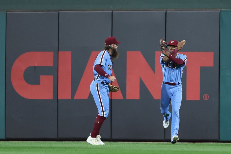 Oct 12, 2023; Philadelphia, Pennsylvania, USA; Philadelphia Phillies center fielder Johan Rojas (18) celebrates with left fielder Brandon Marsh (16) after catching the fly ball of Atlanta Braves designated hitter Marcell Ozuna (20) to end the top of the seventh inning during game four of the NLDS for the 2023 MLB playoffs at Citizens Bank Park. Mandatory Credit: Bill Streicher-USA TODAY Sports