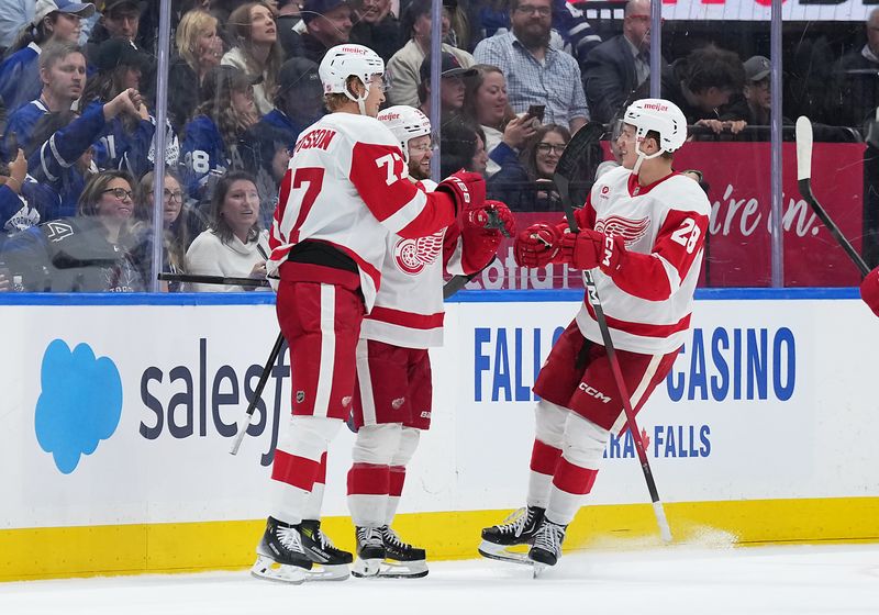 Oct 2, 2025; Toronto, Ontario, CAN; Detroit Red Wings right wing Alex DeBrincat (93) scores a goal and celebrates with right wing Michael Brandsegg-Nygard (28) against the Toronto Maple Leafs during the third period at Scotiabank Arena. Mandatory Credit: Nick Turchiaro-Imagn Images