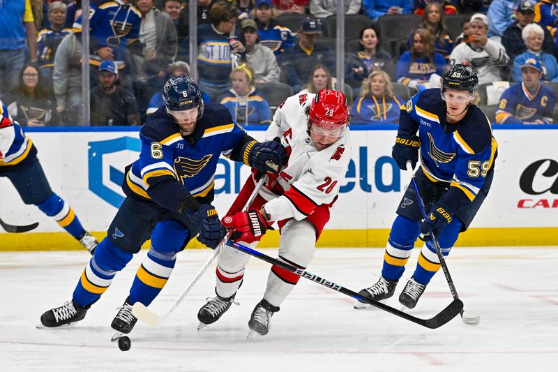 Apr 12, 2024; St. Louis, Missouri, USA;  St. Louis Blues defenseman Marco Scandella (6) and Carolina Hurricanes left wing Brendan Lemieux (28) battle for the puck during the first period at Enterprise Center. Mandatory Credit: Jeff Curry-USA TODAY Sports