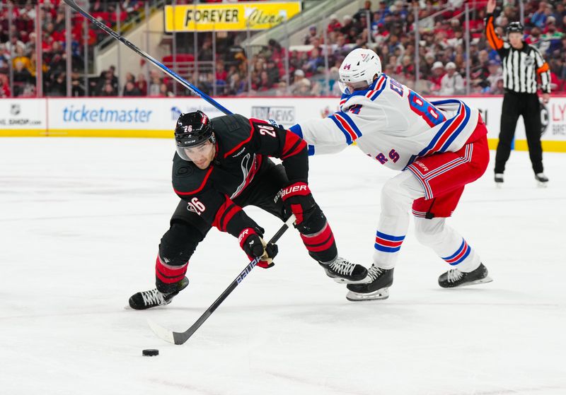 Nov 27, 2024; Raleigh, North Carolina, USA;  New York Rangers center Adam Edstrom (84) defends against Carolina Hurricanes center Seth Jarvis (24) during the first period at Lenovo Center. Mandatory Credit: James Guillory-Imagn Images