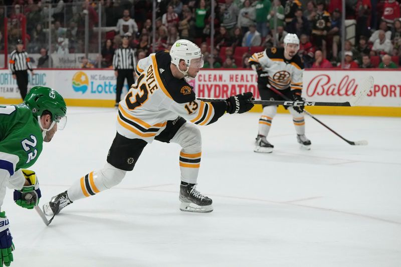 Mar 26, 2023; Raleigh, North Carolina, USA;  Boston Bruins center Charlie Coyle (13) takes a shot against the Carolina Hurricanes during the second period at PNC Arena. Mandatory Credit: James Guillory-USA TODAY Sports