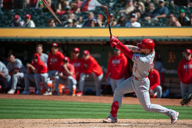 Apr 29, 2023; Oakland, California, USA; Cincinnati Reds right fielder Jake Fraley (27) breaks his bat on an RBI double during the ninth inning against the Oakland Athletics at RingCentral Coliseum. Mandatory Credit: Ed Szczepanski-USA TODAY Sports