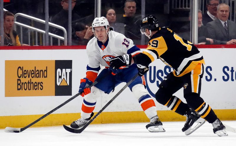 Feb 20, 2024; Pittsburgh, Pennsylvania, USA; New York Islanders center Mathew Barzal (13) handles the puck against Pittsburgh Penguins right wing Reilly Smith (19) during the first period at PPG Paints Arena. Mandatory Credit: Charles LeClaire-USA TODAY Sports