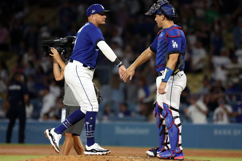 Aug 3, 2023; Los Angeles, California, USA;  Los Angeles Dodgers shortstop Miguel Rojas (11) celebrates a victory with catcher Austin Barnes (15) after defeating the Oakland Athletics 8-2 at Dodger Stadium. Mandatory Credit: Kiyoshi Mio-USA TODAY Sports