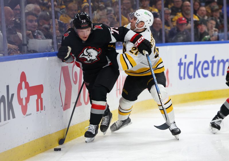Dec 27, 2025; Buffalo, New York, USA;  Buffalo Sabres defenseman Zach Metsa (73) and Boston Bruins center Alex Steeves (21) go after a loose puck during the first period at KeyBank Center. Mandatory Credit: Timothy T. Ludwig-Imagn Images