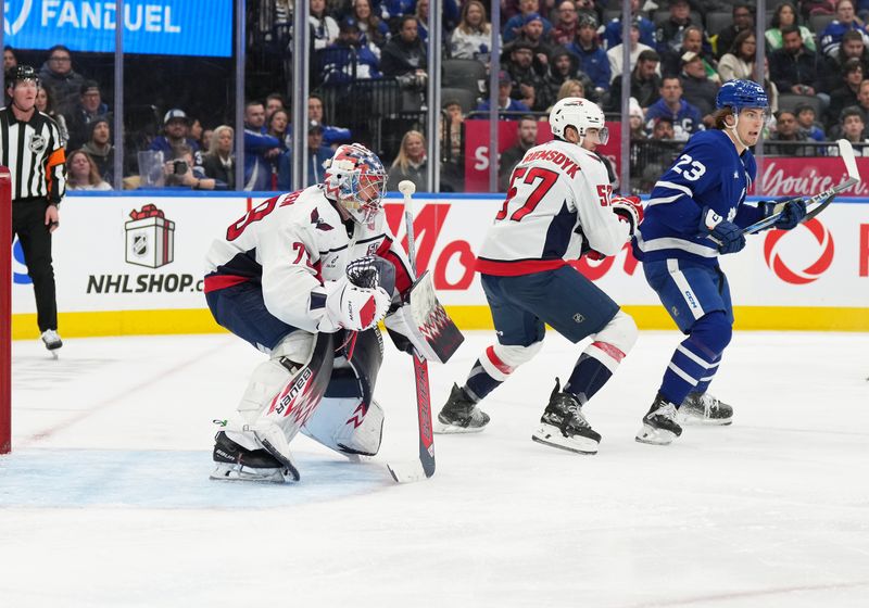 Dec 6, 2024; Toronto, Ontario, CAN; Toronto Maple Leafs left wing Matthew Knies (23) battles with Washington Capitals defenseman Trevor van Riemsdyk (57) in front of goaltender Charlie Lindgren (79) during  the third period at Scotiabank Arena. Mandatory Credit: Nick Turchiaro-Imagn Images