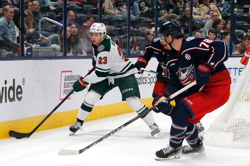 Oct 19, 2024; Columbus, Ohio, USA; Minnesota Wild center Marco Rossi (23) picks up a loose puck as Columbus Blue Jackets defenseman Damon Severson (78) during the third period  at Nationwide Arena. Mandatory Credit: Russell LaBounty-Imagn Images