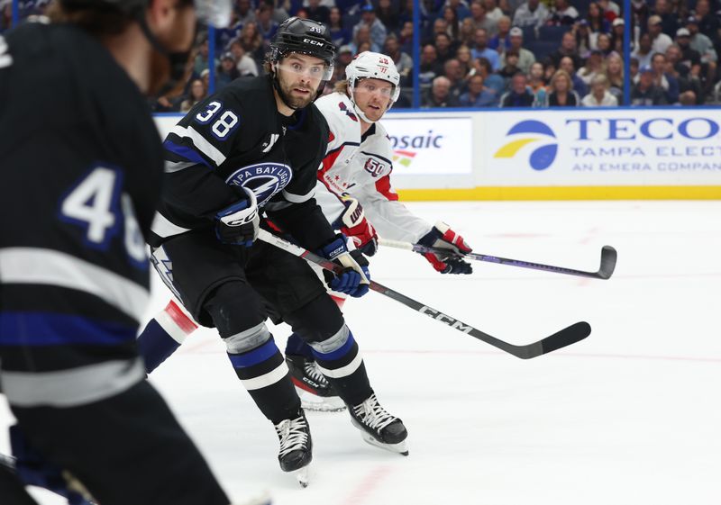 Oct 26, 2024; Tampa, Florida, USA; Tampa Bay Lightning left wing Brandon Hagel (38) skates as Washington Capitals defenseman Rasmus Sandin (38) defends during the first period at Amalie Arena. Mandatory Credit: Kim Klement Neitzel-Imagn Images