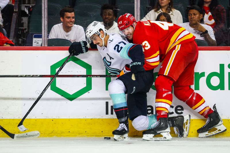 Sep 23, 2025; Calgary, Alberta, CAN; Seattle Kraken left wing Mason Marchment (27) and Calgary Flames right wing Adam Klapka (43) battles for the puck during the third period at Scotiabank Saddledome. Mandatory Credit: Sergei Belski-Imagn Images