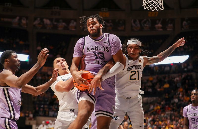 Jan 9, 2024; Morgantown, West Virginia, USA; Kansas State Wildcats forward Will McNair Jr. (13) grabs a rebound against West Virginia Mountaineers guard RaeQuan Battle (21) during the second half at WVU Coliseum. Mandatory Credit: Ben Queen-USA TODAY Sports