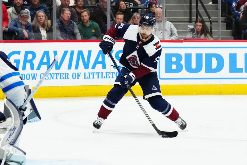 Dec 7, 2023; Denver, Colorado, USA; Colorado Avalanche left wing Tomas Tatar (90) shoots the puck in the second period against the Winnipeg Jets at Ball Arena. Mandatory Credit: Ron Chenoy-USA TODAY Sports