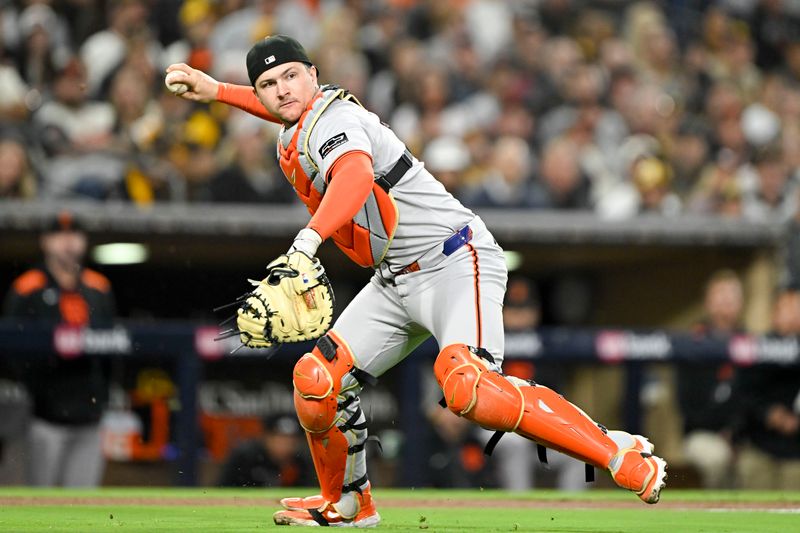 Apr 29, 2025; San Diego, California, USA; San Francisco Giants catcher Patrick Bailey (14) throws San Diego Padres right fielder Fernando Tatis Jr. (23) out at first base during the fourth inning at Petco Park. Mandatory Credit: Denis Poroy-Imagn Images
