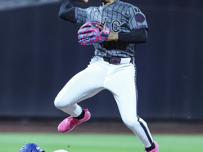 May 24, 2025; New York City, New York, USA;  New York Mets shortstop Francisco Lindor (12) leaps over Los Angeles Dodgers left fielder Andy Pages (44) attempting to complete a double play in the seventh inning at Citi Field. Mandatory Credit: Wendell Cruz-Imagn Images